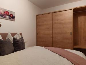 1 dormitorio con armario grande de madera y cama en Apart Jakob, en Schwendau