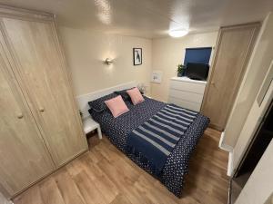 a bedroom with a bed with two pink pillows at Kestral Pet Friendly Caravan in Alford