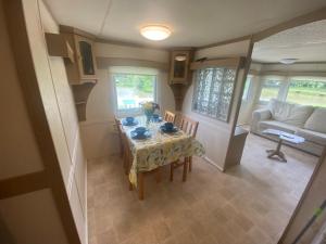 a small dining room with a table and a couch at Kestral Pet Friendly Caravan in Alford