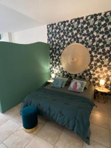 a bedroom with a green bed with a large mirror at Le Loft PATIO, au coeur du village in Saint-Rémy-de-Provence
