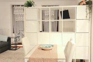 soggiorno con tavolo e armadietto bianco di Grazioso appartamento in centro storico a Trento