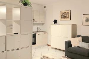 soggiorno con armadi bianchi e divano di Grazioso appartamento in centro storico a Trento