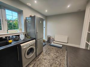 a kitchen with a refrigerator and a washing machine at Great place in Newcastle in Newcastle upon Tyne