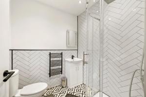 een witte badkamer met een douche en een toilet bij Elegant Yorkshire Abode - Great Location - Sleeps 19 in Castleford