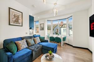 - un salon avec un canapé bleu et une table dans l'établissement Elegant Yorkshire Abode - Great Location - Sleeps 19, à Castleford