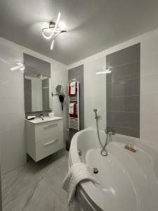 a bathroom with a bath tub and a ceiling fan at Hotel Le Saint-Yves in Le Tr&eacute;port