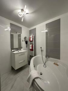 a bathroom with a bath tub and a ceiling fan at Hotel Le Saint-Yves in Le Tréport