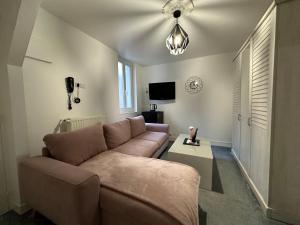 a living room with a couch and a tv at Hotel Le Saint-Yves in Le Tréport