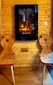two chairs sitting in front of a fireplace at Refuge des Cimes in Saint-Laurent-en-Grandvaux
