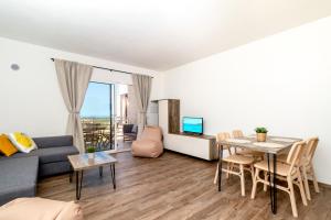 ein Wohnzimmer mit einem Sofa und einem Tisch in der Unterkunft Sardegna Appartamenti, Via Sedini in Trinità dʼAgultu