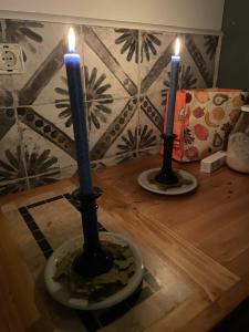 two candles sitting on top of a wooden table at Lindenhof ChezArtistes in Loose