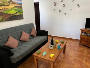een woonkamer met een bank en een tafel bij Casa de campo Yuco in Tinajo +9 foto's