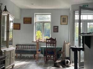 ein Wohnzimmer mit einem Tisch und einem Hund auf dem Boden in der Unterkunft Lindenhof ChezArtistes in Loose