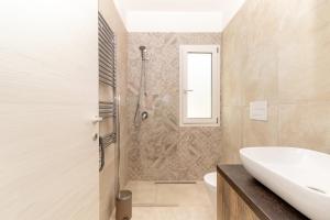 y baño con ducha, lavabo y aseo. en Sardegna Appartamenti, Via Sedini, en Trinità dʼAgultu