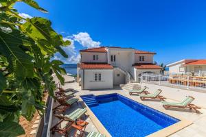 a villa with a swimming pool and a house at Villa Katarina in Stanići