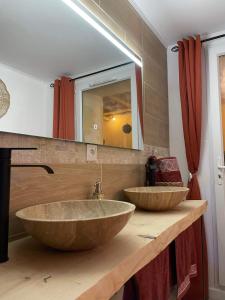 baño con 2 lavabos de piedra grandes en una encimera en Velours & Balnéo, en Saint-Nazaire