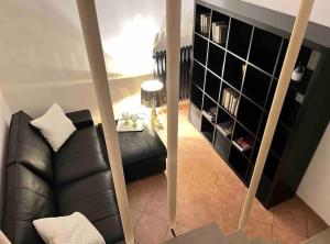 a living room with a black leather couch and a mirror at Life is Beautiful Design LOFT Navigli Romolo, SmartTV, WiFi, AC and street parking in Milan