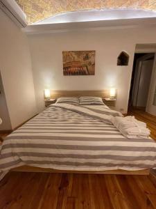 1 dormitorio con 1 cama grande con manta a rayas en CASA ANTICA - antique apartment with private terrace, en Roma