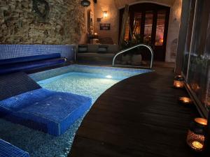 a swimming pool with a bed and a tub at Les Vinyes Alojamiento Rural Boutique & SPA in Vilardida