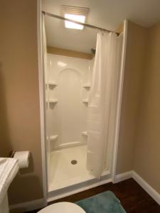 een badkamer met een douche en een toilet bij Private basement bedroom with private bathroom, kitchen, and living room with large screen television in McCordsville