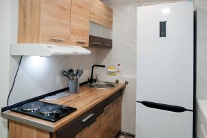 a small kitchen with a stove and a refrigerator at Уютный Sunny hostel in Almaty