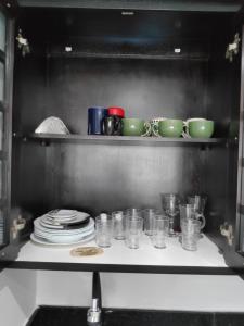 a shelf with dishes and cups and plates on it at Lindo Flat Luxuoso em Moema Ibirapuera - Apto 1320 in São Paulo
