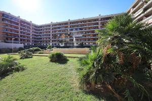 a large apartment building with palm trees in front of it at Alla fiera di Roma in Ponte Galeria