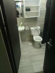 uma casa de banho com um WC branco e um lavatório. em 1255 Palm Ridge Vipingo Estate Apartments em Kilifi