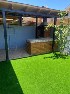 un patio de hierba verde frente a una casa en Casa 3 habitaciones exclusiva valle lo campino, en Santiago