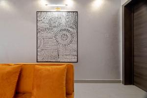 an orange couch in a room with a picture on the wall at Luxury 3 Bed Serviced Apartment in Lekki Phase 1 in Lagos