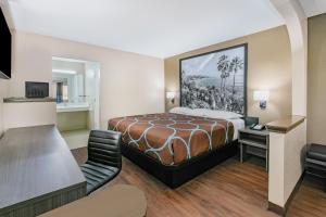 a hotel room with a bed and a desk at Super 8 by Wyndham Moss Point in Moss Point