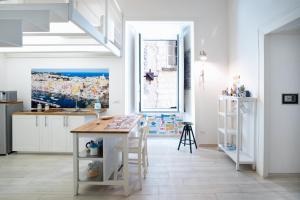 een witte keuken met een tafel en een raam bij Mare Napoli in Napels