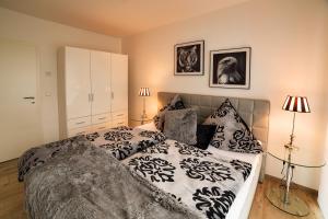 a bedroom with a bed with black and white sheets and pillows at Charming Apartments am See in Bad Saarow