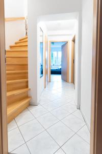 a hallway with a white tile floor and stairs at CaSa Apartment Svea - 2x Parken-Amazon Prime-Terasse-Garten-Vollausstattung in Erfurt