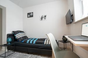 um quarto com uma cama e uma secretária com um computador portátil em CaSa Apartment Svea - 2x Parken-Amazon Prime-Terasse-Garten-Vollausstattung em Erfurt