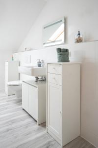 a white bathroom with a sink and a mirror at CaSa Apartment Svea - 2x Parken-Amazon Prime-Terasse-Garten-Vollausstattung in Erfurt
