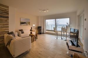 - un salon avec un canapé et une table dans l'établissement Charming Apartments am See, à Bad Saarow