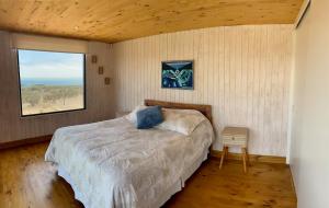 een slaapkamer met een groot bed en een raam bij Cómoda Casa en la Playa in Guaquen