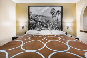 a large bed in a room with a painting on the wall at Super 8 by Wyndham Moss Point in Moss Point