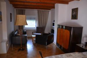 een woonkamer met een bank, een stoel en een lamp bij Pension U akátu in Praag