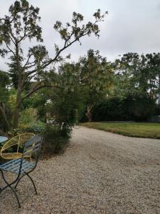 a bench sitting on the side of a gravel road at Beehive Cottage in Beccles