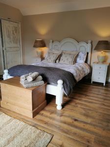 a bedroom with a large white bed with two lamps at Beehive Cottage in Beccles