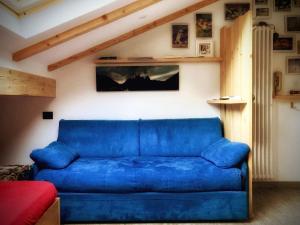 a blue couch sitting in a living room at incantevole mansarda in val di Fassa in Alba di Canazei