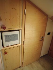 a microwave sitting on a shelf next to a door at incantevole mansarda in val di Fassa in Alba di Canazei