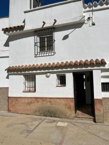 a white building with barred windows and a door at Esencia de Arcos in Arcos de la Frontera