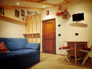 阿爾巴迪卡納澤伊的住宿－incantevole mansarda in val di Fassa，客厅设有蓝色的沙发和木门。