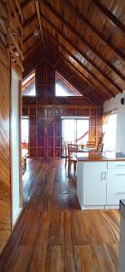 Chalet del Pacífico في جاما: غرفة كبيرة بجدران خشبية ومطبخ وأرضيات خشبية