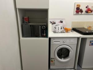 een keuken met een wasmachine en een magnetron bij Studio cosy et confortable collé à La Défense in Courbevoie