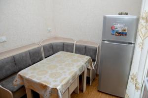 a small kitchen with a table and a refrigerator at Leila in Tbilisi City