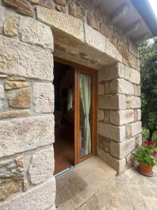 Casa de piedra con ventana en una pared de piedra en Su Lidone, en Ozieri